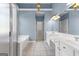 Bright bathroom with double vanity, white cabinetry, walk-in shower, soaking tub and blue walls at 125 Lake Park Dr, Sharpsburg, GA 30277