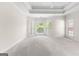 Spacious bedroom with a tray ceiling, neutral carpet, multiple windows offering natural light and exterior views at 125 Lake Park Dr, Sharpsburg, GA 30277