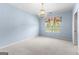 Carpeted bedroom with natural light from the window and traditional chandelier at 125 Lake Park Dr, Sharpsburg, GA 30277