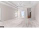 Large bedroom with tray ceiling, neutral carpet, ceiling fan, and french doors leading to an ensuite bath at 125 Lake Park Dr, Sharpsburg, GA 30277