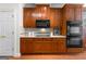 Traditional kitchen showcasing custom wood cabinetry, black appliances, quartz countertops and hardwood flooring at 125 Lake Park Dr, Sharpsburg, GA 30277
