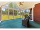 Bright sunroom with ceiling fan and screened windows overlooking a serene backyard at 125 Lake Park Dr, Sharpsburg, GA 30277