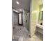 Modern bathroom with gray tile flooring, white marble walls, walk-in shower and floating sink at 1503 Wingate Way # 1503, Sandy Springs, GA 30350