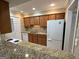 Kitchen featuring granite countertops, wood cabinets and white appliances at 1503 Wingate Way # 1503, Sandy Springs, GA 30350