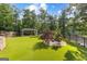 Backyard with manicured lawn featuring mature trees, stone landscaping, and covered outdoor living space at 4320 Blue Ridge Dr, Douglasville, GA 30135