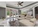 Open-concept living area with a modern white leather sofa, open doors to the outdoor patio, and a dining room nearby at 4320 Blue Ridge Dr, Douglasville, GA 30135