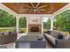 Cozy outdoor seating area with a stone fireplace, ceiling fan, and comfortable seating at 4320 Blue Ridge Dr, Douglasville, GA 30135