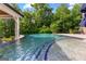 Zero entry backyard pool with waterfall feature, blue tile, mature trees, and lounge chair at 4320 Blue Ridge Dr, Douglasville, GA 30135