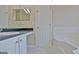 A bathroom features a built in vanity, white cabinets, a large mirror, and a separate bathtub at 10690 Tara Village Way, Joneboro, GA 30238