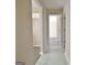 Hallway with white ceramic flooring leading to another room with vinyl flooring at 10690 Tara Village Way, Joneboro, GA 30238