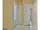 A hallway has tile floors and leads to several bedrooms with neutral-colored walls at 10690 Tara Village Way, Joneboro, GA 30238