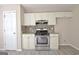 Modern kitchen with stainless steel range, stylish tile backsplash and white cabinetry at 10690 Tara Village Way, Joneboro, GA 30238