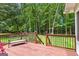 Relaxing back deck features wooden flooring, railing, bench and private, wooded backyard at 145 Adams Ct, Fayetteville, GA 30214