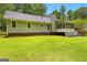 Expansive backyard showcasing a well-maintained lawn, screened in porch, and the home's exterior at 145 Adams Ct, Fayetteville, GA 30214