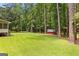Spacious lawn in a wooded backyard with a wood shed and screened porch at 145 Adams Ct, Fayetteville, GA 30214