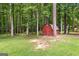 Wood shed in a wooded backyard with lush grass and mature trees at 145 Adams Ct, Fayetteville, GA 30214