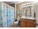 Cozy bathroom featuring a wooden vanity, decorative mirror, and a beach-themed shower curtain at 145 Adams Ct, Fayetteville, GA 30214