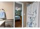 A serene bathroom space with a shower curtain and a glimpse into the adjacent bedroom at 145 Adams Ct, Fayetteville, GA 30214