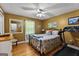 A cozy bedroom with warm yellow walls, hardwood floors, and a comfortable queen-sized bed at 145 Adams Ct, Fayetteville, GA 30214