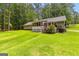 Home exterior featuring a large, green backyard with a screened porch and mature trees at 145 Adams Ct, Fayetteville, GA 30214