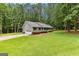 Well maintained home with a lush green lawn, mature trees, and an attached garage at 145 Adams Ct, Fayetteville, GA 30214
