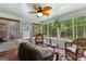 Relaxing screened porch with comfortable seating, ceiling fan, and views of the wooded backyard at 145 Adams Ct, Fayetteville, GA 30214