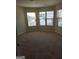 Large bedroom with three windows provides plenty of natural light onto the neutral toned walls and carpet at 556 Emporia Loop, Mcdonough, GA 30253