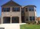 Charming two-story home featuring brick and siding exterior, two car garage, and a well-maintained lawn at 556 Emporia Loop, Mcdonough, GA 30253