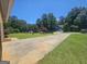 Spacious driveway view showcasing a charming home surrounded by mature trees and greenery at 212 Hunting Court, Jonesboro, GA 30236
