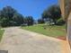 Wide driveway offers a glimpse of the peaceful, tree-lined neighborhood and nearby homes at 212 Hunting Court, Jonesboro, GA 30236