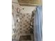 Shower stall featuring a shower head and tiled walls and built-in shelves at 212 Hunting Court, Jonesboro, GA 30236