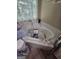 Corner soaking tub in a bathroom, featuring gold-tone faucet and window with sheer curtains at 212 Hunting Court, Jonesboro, GA 30236