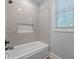 Relaxing bathroom featuring a jetted tub, neutral tile and ample natural light at 11807 Alcovy Rd, Covington, GA 30014