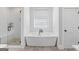 Bright bathroom featuring a soaking tub, separate shower, and tile flooring at 11807 Alcovy Rd, Covington, GA 30014