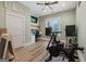 Bright bedroom featuring home gym equipment and a built in desk with a window view at 11807 Alcovy Rd, Covington, GA 30014