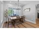 Bright dining room with a rustic table set, shiplap walls, a modern chandelier, and backyard views at 11807 Alcovy Rd, Covington, GA 30014
