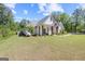 A white farmhouse-style home on a green lawn with manicured landscaping, and a wood porch with a 'welcome' sign at 11807 Alcovy Rd, Covington, GA 30014
