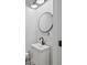 Cozy half bathroom featuring a modern vanity, round mirror, and farmhouse style at 11807 Alcovy Rd, Covington, GA 30014