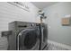 Functional laundry room featuring stainless steel washer and dryer with patterned tile floor at 11807 Alcovy Rd, Covington, GA 30014