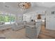 Spacious living room featuring a stylish ceiling fan, an oversized sectional sofa, and views of the pool through large windows at 11807 Alcovy Rd, Covington, GA 30014