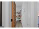 Walk-in pantry with a wooden door and glass panels with ample shelving for storage at 11807 Alcovy Rd, Covington, GA 30014