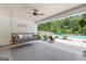 Covered patio features a swing, ceiling fan, and adirondack chairs overlooking the pool and backyard at 11807 Alcovy Rd, Covington, GA 30014