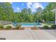In-ground pool surrounded by lush landscaping and a spacious concrete patio at 11807 Alcovy Rd, Covington, GA 30014