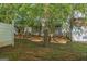 View of the backyard featuring a wooden fence and green trees, with glimpses of the house through the foliage at 11439 South Grove Dr, Hampton, GA 30228
