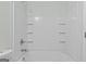 Clean white tub and shower combination with tile surround and built-in shelving at 11439 South Grove Dr, Hampton, GA 30228