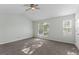 Bright bedroom with neutral carpet features a ceiling fan and natural light from two windows at 11439 South Grove Dr, Hampton, GA 30228
