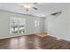 Inviting living room with hardwood floors, large window, ceiling fan and neutral paint at 11439 South Grove Dr, Hampton, GA 30228