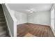 Bright living room features hardwood floors, a ceiling fan, and staircase to the upper level at 11439 South Grove Dr, Hampton, GA 30228