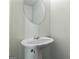 Neat powder room featuring pedestal sink, round mirror, and neutral color paint at 11439 South Grove Dr, Hampton, GA 30228
