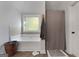 Clean bathroom featuring a garden tub with tile surround, neutral walls, and tiled floors at 1412 Short Ct, Mcdonough, GA 30252